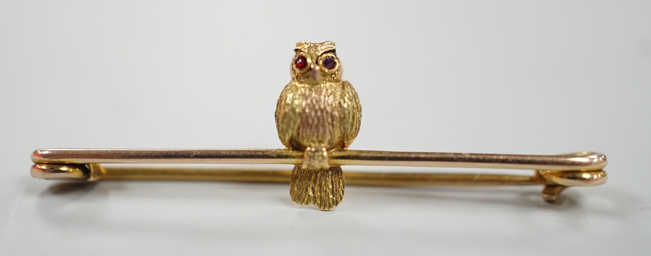 A mid 20th century two colour 9ct owl bar brooch, with cabochon eyes, 38mm, gross weight 1.3 grams.